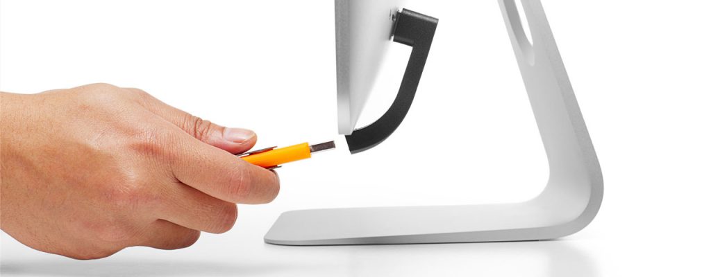 This image is of the bluelounge Jimi, a USB extension piece for the back of an Apple monitor. A hand holding a yellow USB drive next to the Jimi.