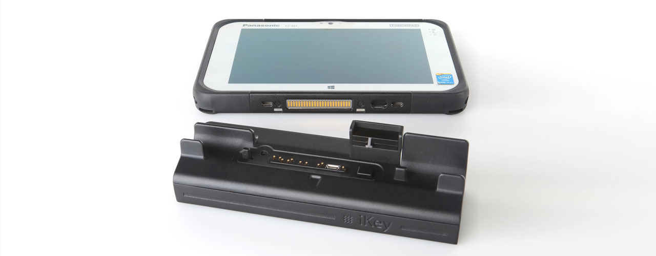 The Micro Dock for the iKey is sitting upright to highlight all the plug ins and port, while the tablet is laying on its back, highlighting the ports that correspond to the dock.