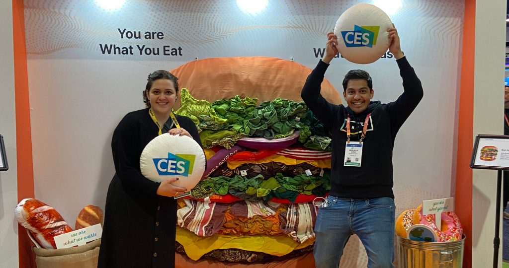 Abhi Shah and Raiza Newberry-Quiroz in front of a giant plush hambuger.