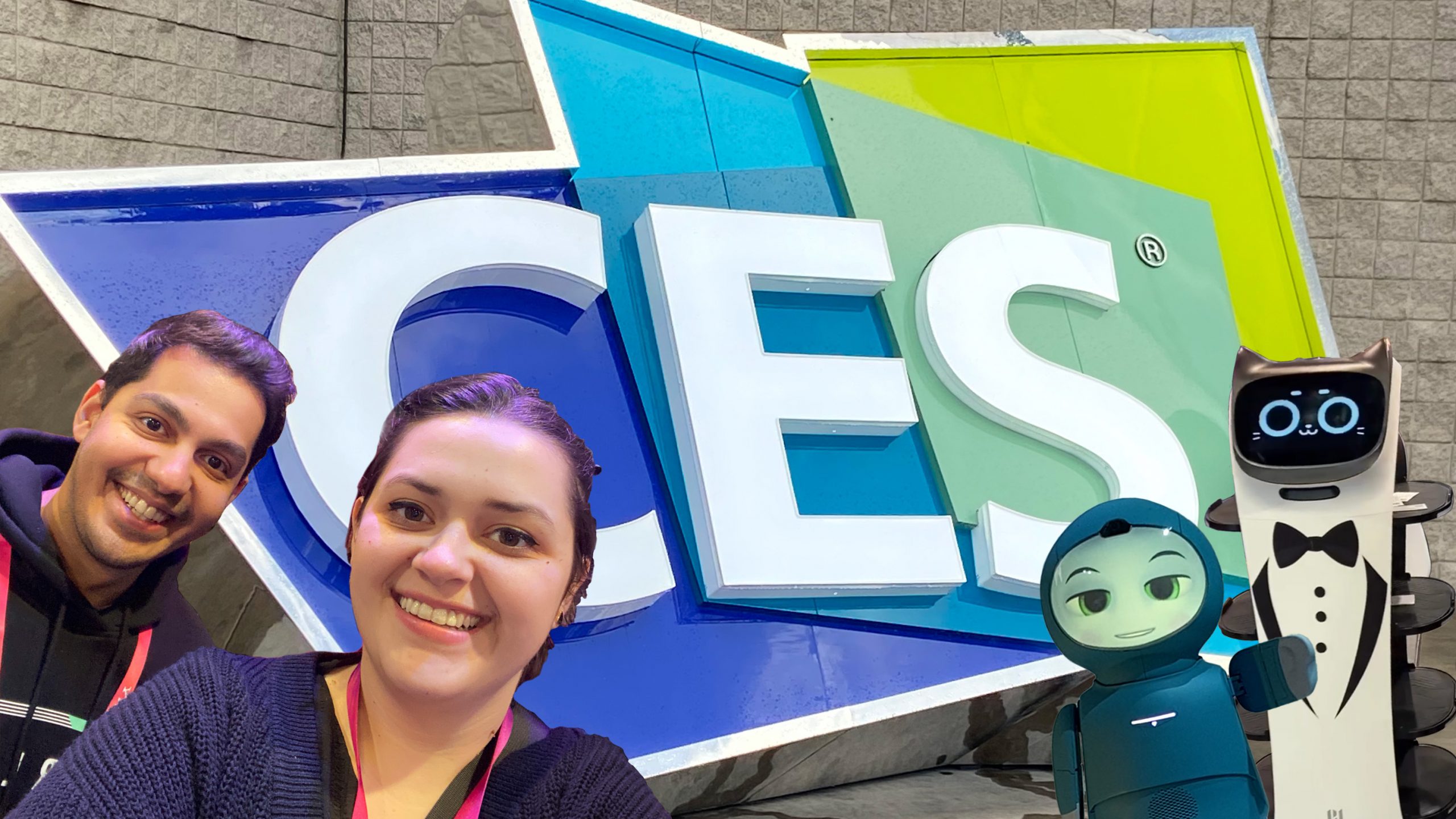 Abhi Shah, Raiza Newberry-Quiroz, Moxie the robot and a serving cat robot in front of a CES board.