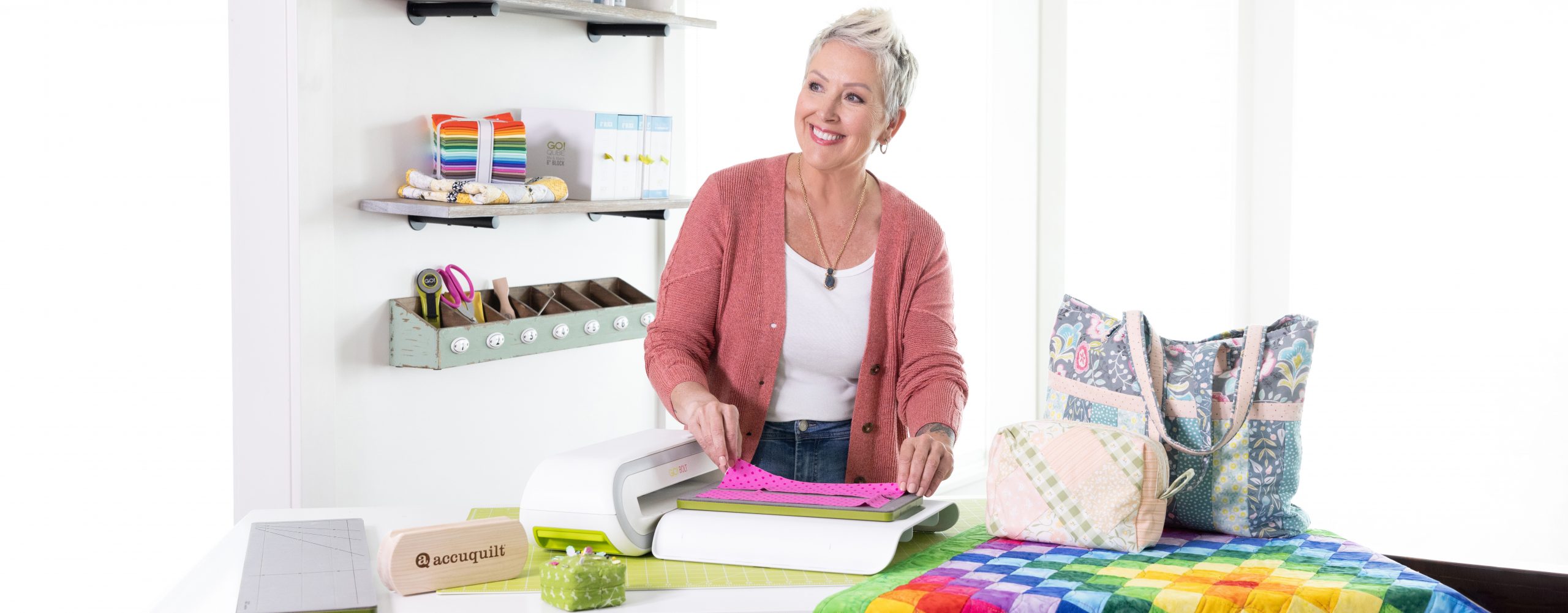 The Accuquilt Go! Bolt in a craft room being used by an older lady.