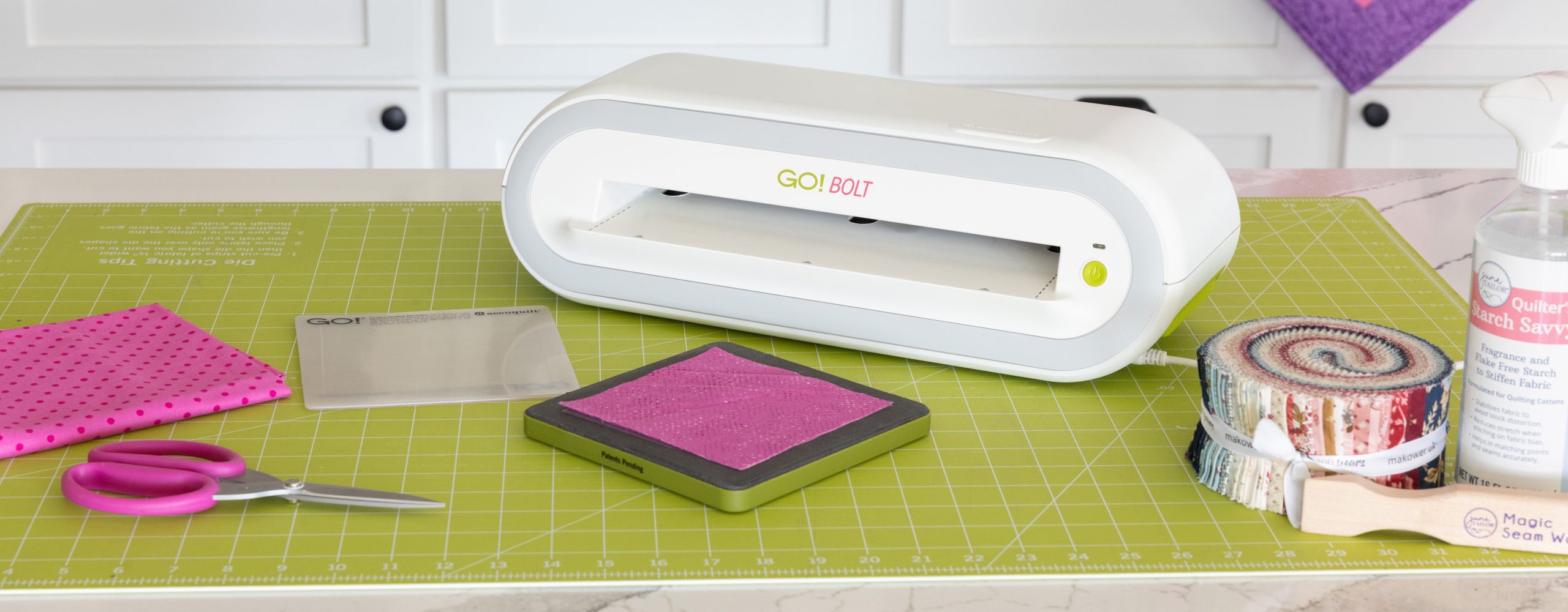 The Accuquilt Go! Bolt on a cutting matt with a die on the matt.