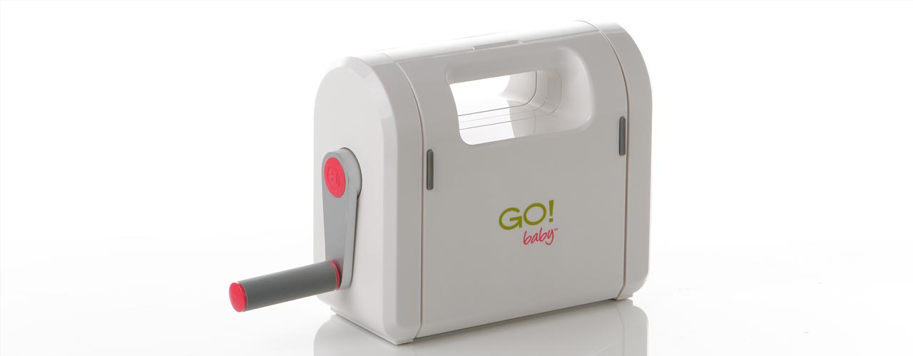 The AccuQuilt Go! baby, a small die cutting fabric cutter, with the cutting tray open.