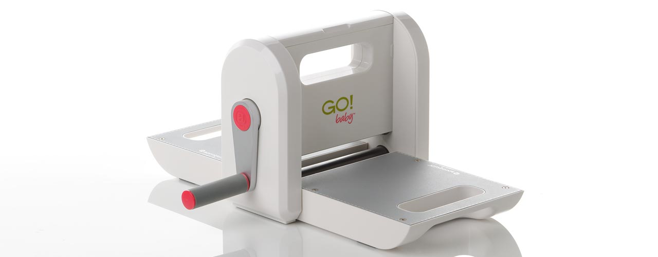 The AccuQuilt Go! baby, a small die cutting fabric cutter, with the cutting tray open. 