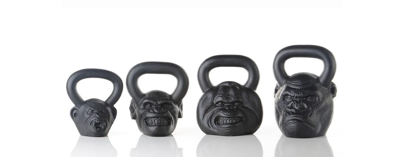 The Onnit kettle bells product line, in order from smallest to largest from left to right: a howler monkey, a chimpanzee, an orangutan, and a gorilla all placed on a reflective surface.